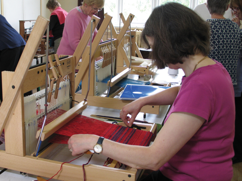 weavers_chesham A weaver using a loom in weaving class- others looms and weavers in the background